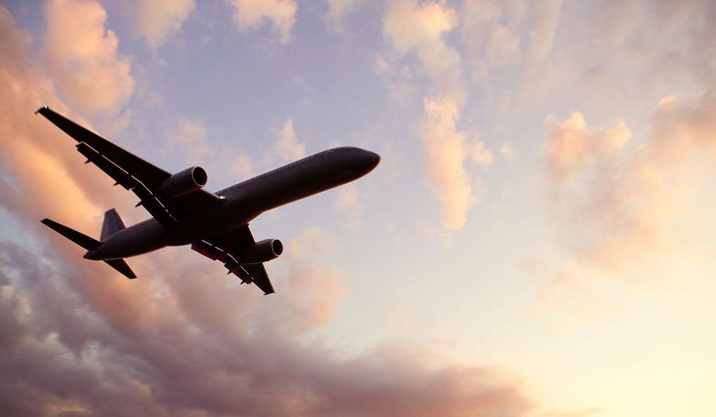 Fliegendes Flugzeug von unten mit Wolken