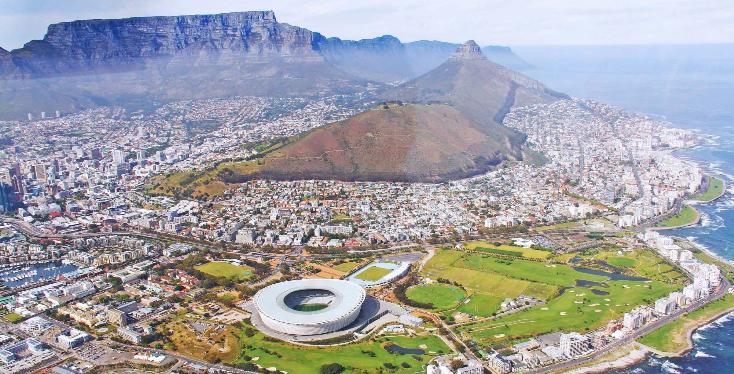 Kapstadt mit einem runden Stadion und dem Tafelberg im Hintergrund