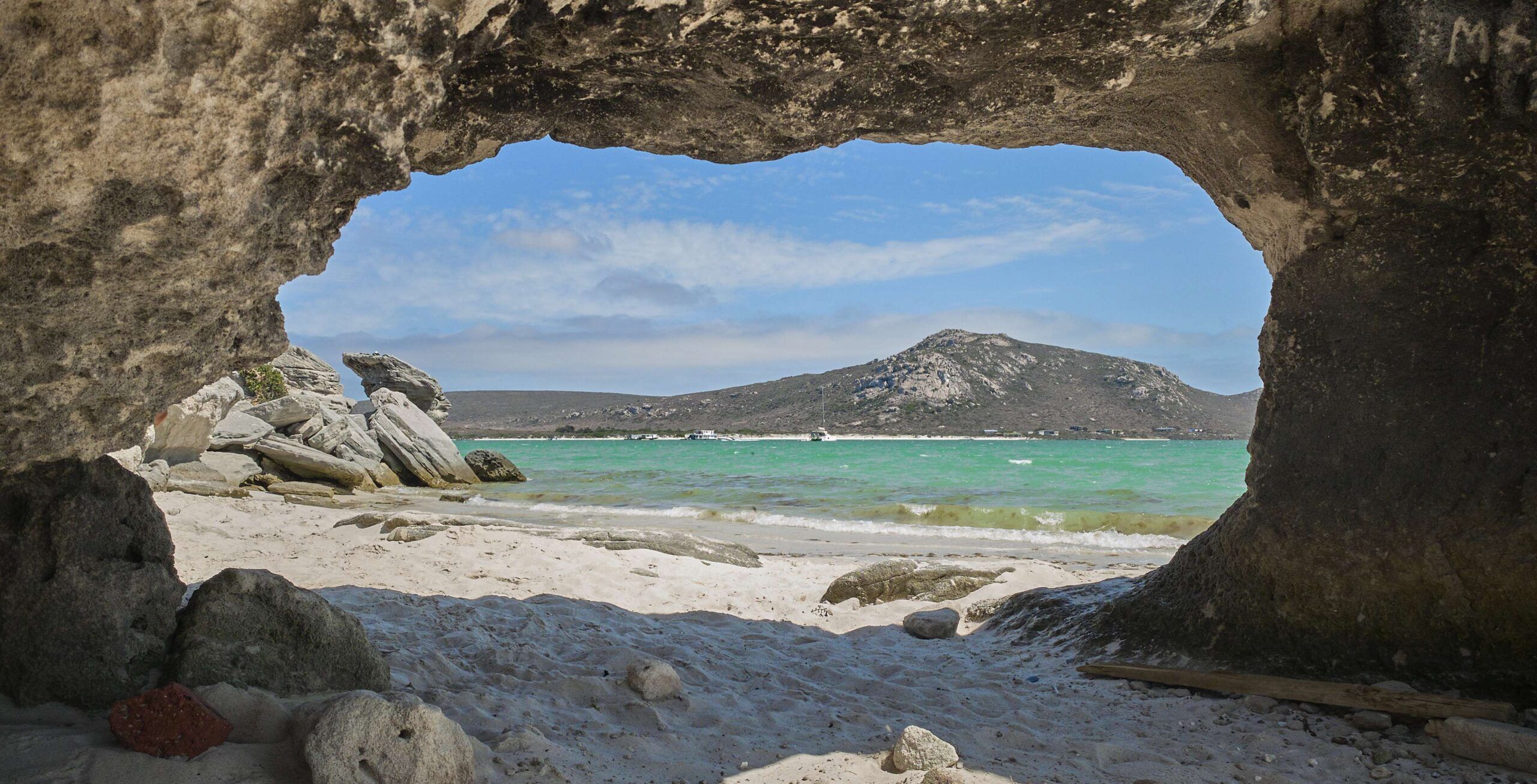 Blick auf Langebaan-Lagune durch eine Höhle mit Strand und blauem Meer