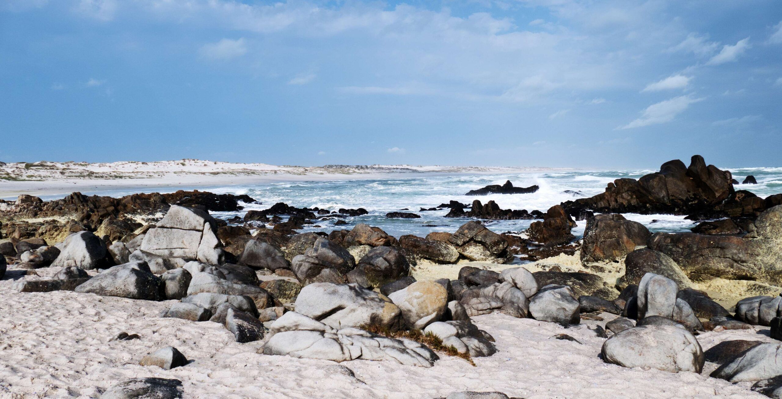 Felsige Küste mit Meer und Wellen im Hintergrund