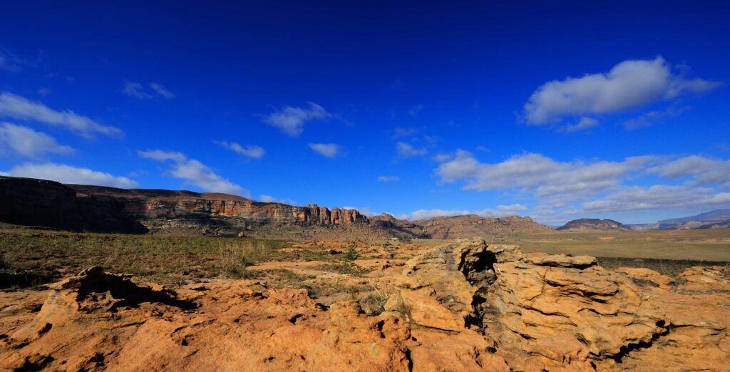 Raue, felsige Landschaft mit Bergen im Hintergrund im Golden Gate Highlands Nationalpark