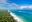 Weißer Sandstrand von Diani Beach mit Bäumen auf einer und dem blauen Meer auf der anderen Seite