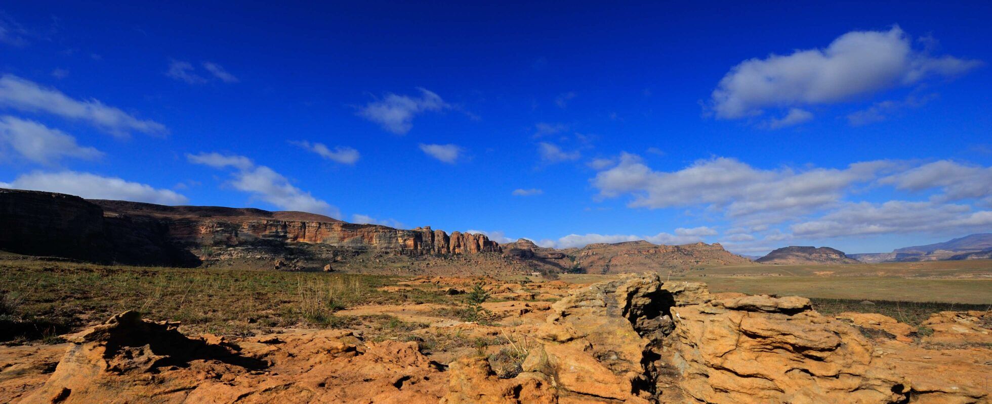Raue, felsige Landschaft mit Bergen im Hintergrund im Golden Gate Highlands Nationalpark