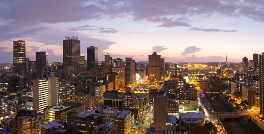 Beleuchtetes Stadtzentrum von Johannesburg bei Nacht