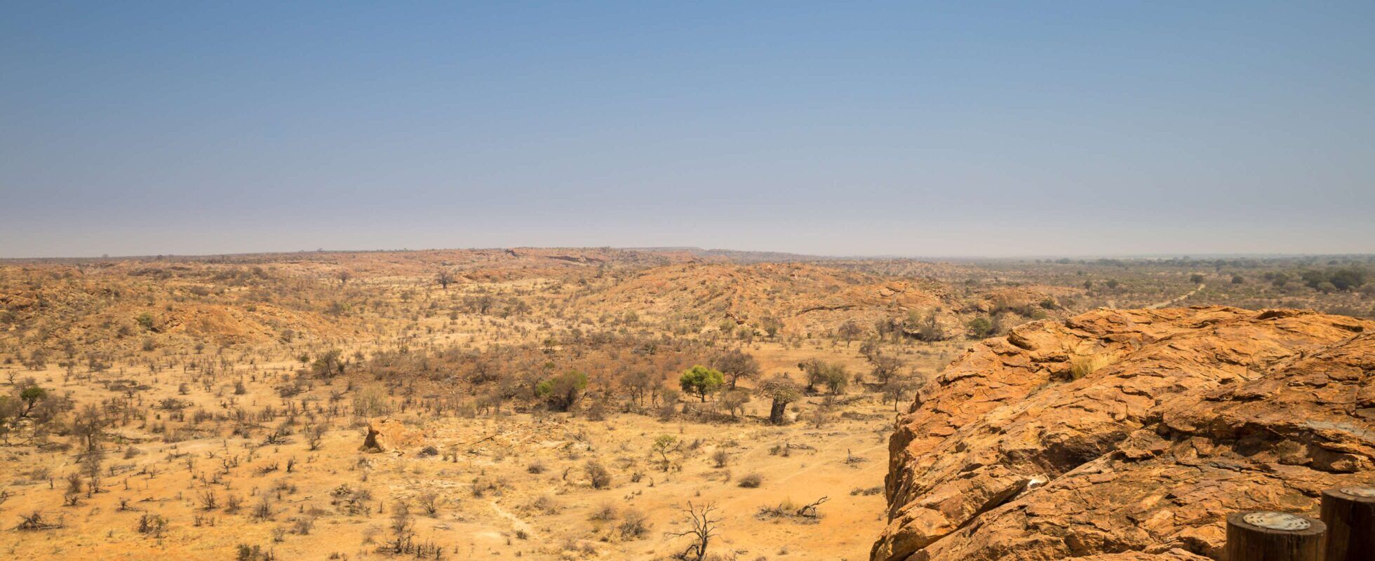 Weitläufiges wüstenähnliches Buschland mit Felsen